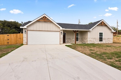 View of front facade featuring a garage and a front yard