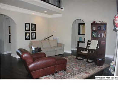 Family rooms has soaring ceilings, hardwood floors