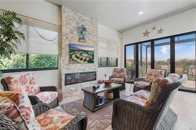 Living room with a large fireplace, recessed lighting, and a textured wall