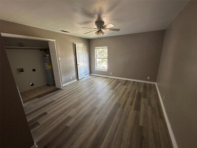Unfurnished bedroom with ceiling fan, gas water heater, and dark hardwood / wood-style floors