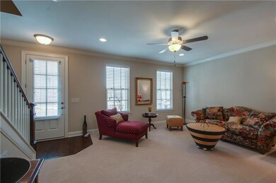 Large downstairs living space with upgraded carpet and ceiling fan.