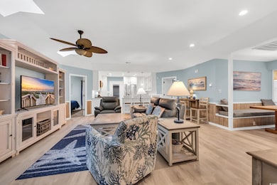 Living room with built in shelves, ceiling fan, an