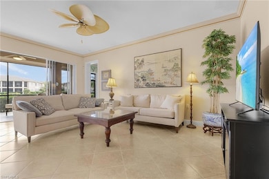 Living area featuring light tile patterned floors, ornamental molding, and a ceiling fan