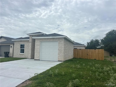View of side of home with roof with shingles, concrete driveway, an attached garage, and concrete block siding