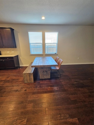 Dining room featuring dark wood finished floors and a textured ceiling