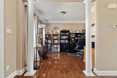 Office space with ornate columns, dark hardwood fl