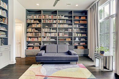 Study/library has an abundance of built-ins, floor to ceiling windows, recessed lighting, and wood flooring.