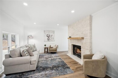 Living area featuring crown molding, a stone fireplace, and recessed lighting