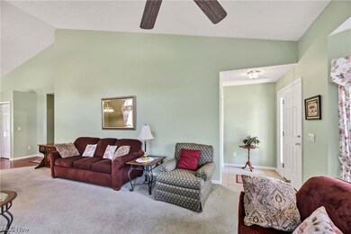 Living room with a high ceiling, light carpet, and lofted ceiling