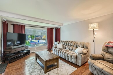 Living room with a large window.  Nice windows. Nice flooring.