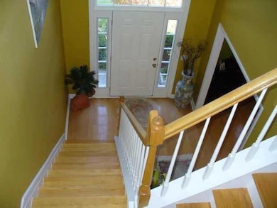 Foyer with wood finished floors and stairway