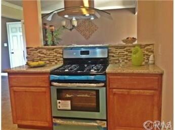 stainless steel stove , kitchen opens to dining ar