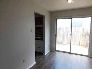 Empty room with dark wood-type flooring and a textured ceiling