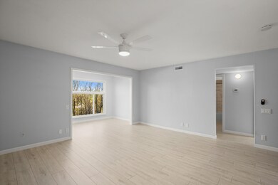 Empty room with a ceiling fan, visible vents, bas