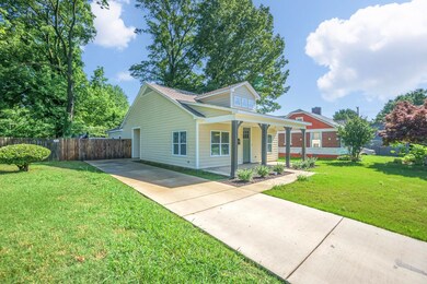 Bungalow with concrete driveway, a porch, a front 