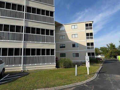 View of building exterior with uncovered parking