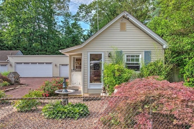 View of front of house featuring dirt driveway and an attached garage