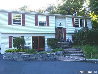 Exterior Front. The stone wall surrounding this go