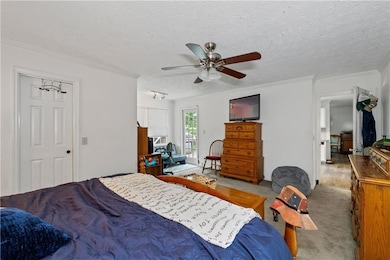 Primary Bedroom with sitting area, door to deck and next to kitchen