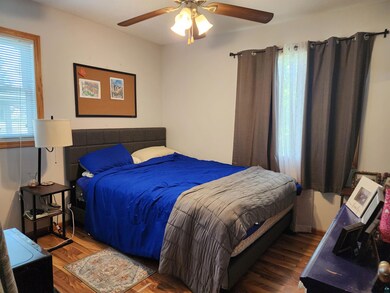 Bedroom with ceiling fan and hardwood / wood-style