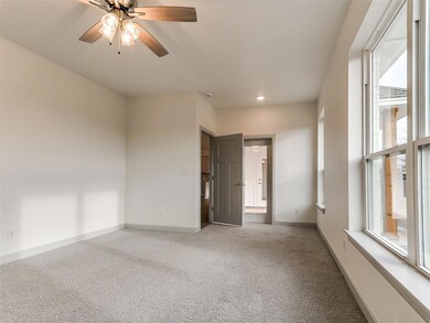 Carpeted spare room with ceiling fan, baseboards, 