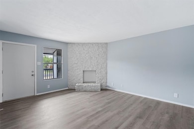 Unfurnished living room featuring baseboards and 