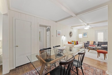 Dining area with hardwood / wood-style flooring, beam ceiling, coffered ceiling, and ceiling fan