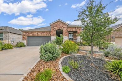 French provincial home featuring brick siding, driveway, an attached garage, and roof with shingles