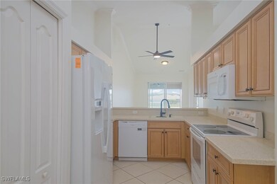 Kitchen with white appliances, a sink, a ceiling f