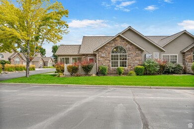View of front of property featuring a front yard, stone siding, stucco siding, and a shingled roof