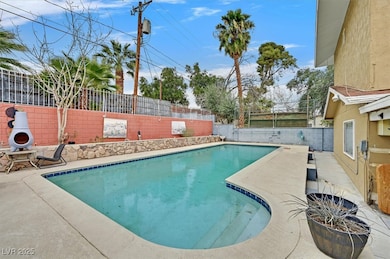 View of pool featuring a fenced backyard and a pat