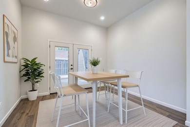 Dining space with french doors, dark wood-type flooring, and recessed lighting
