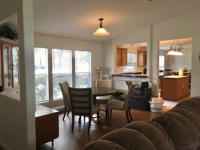 Formal dining just left of entry has floor to ceiling windows to bring in light and a view. Note the breakfast bar to the kitchen.