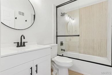 Bathroom featuring vanity and combined bath / shower with glass door