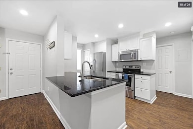Kitchen featuring baseboards, a sink, a peninsula,