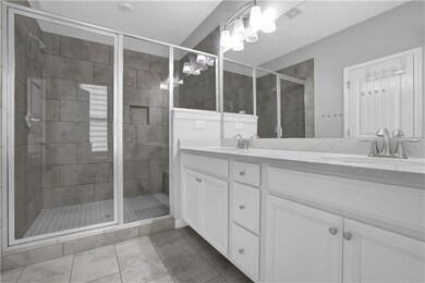 Full bathroom with double vanity and a stall shower