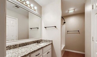 Bathroom featuring bathtub / shower combination, wood-type flooring, and vanity with extensive cabinet space