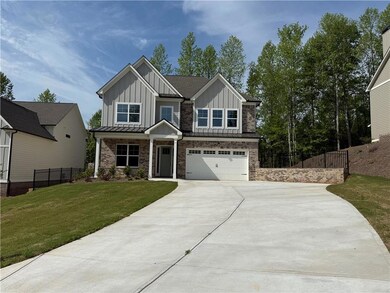 Craftsman inspired home featuring board and batten siding, driveway, a garage, a porch, and brick siding