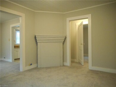 Living Room: Room features include carpet flooring, fresh paint, a window for natural lighting, and crown molding. Fireplace should be inspected by a licensed professional before using. You do loose some floor space due to location of fireplace.