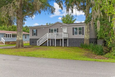 View of front of property with stairs and a front lawn