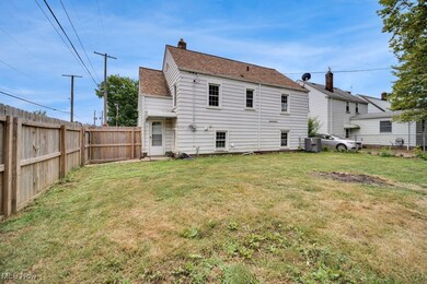 Rear view of house featuring central air condition unit and a yard