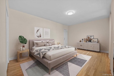 Bedroom with light wood finished floors and baseboards