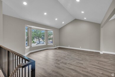Unfurnished living room with light wood-type flooring, lofted ceiling, and recessed lighting