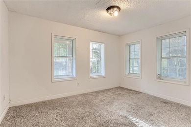Spare room featuring carpet flooring, a textured 