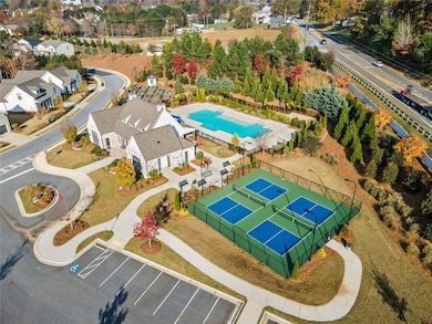 Aerial view of the clubhouse and amenities!  Beautiful pool and clubhouse with meeting room and full kitchen.  Pickle ball courts, pool and community garden and a fire pit!