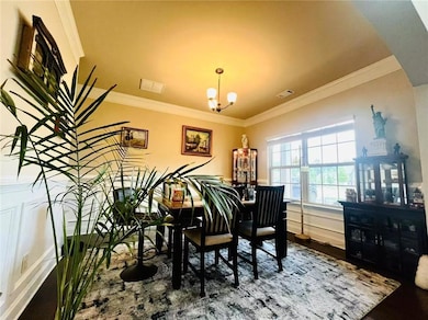 Dining room featuring a chandelier, ornamental molding, and wood finished floors