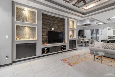 Living room with built in shelves, ceiling fan, light tile patterned flooring, and sink