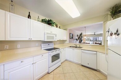 Kitchen with sink, white appliances, light tile pa