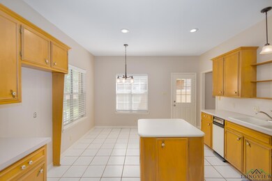 Kitchen featuring open shelves, light countertops, a center island, hanging light fixtures, and light tile patterned floors