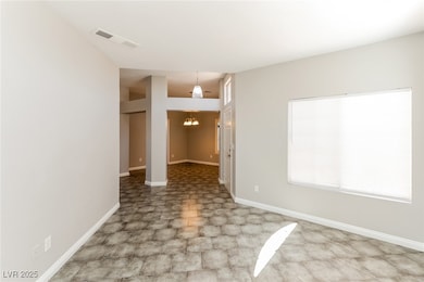Unfurnished room featuring a chandelier and basebo